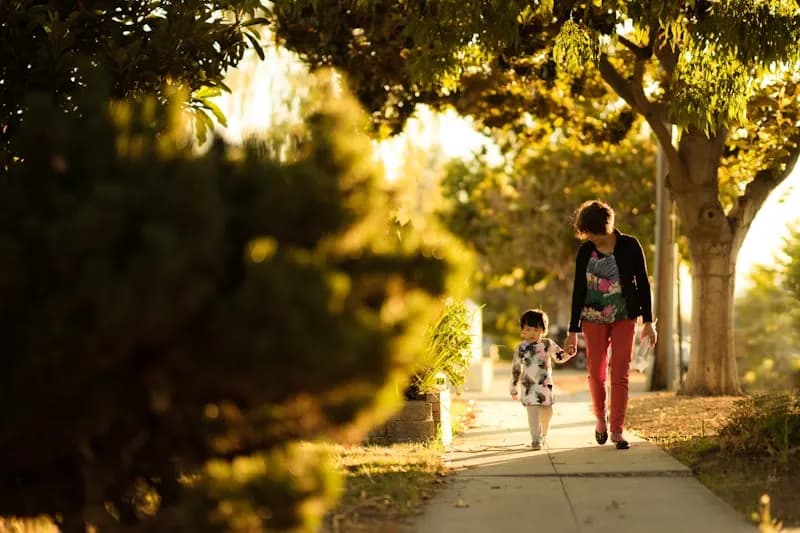 A woman holding a child while walking