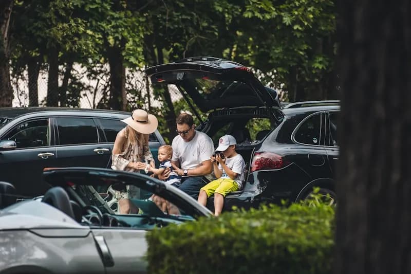 A group of friends sitting in the open boot of a car